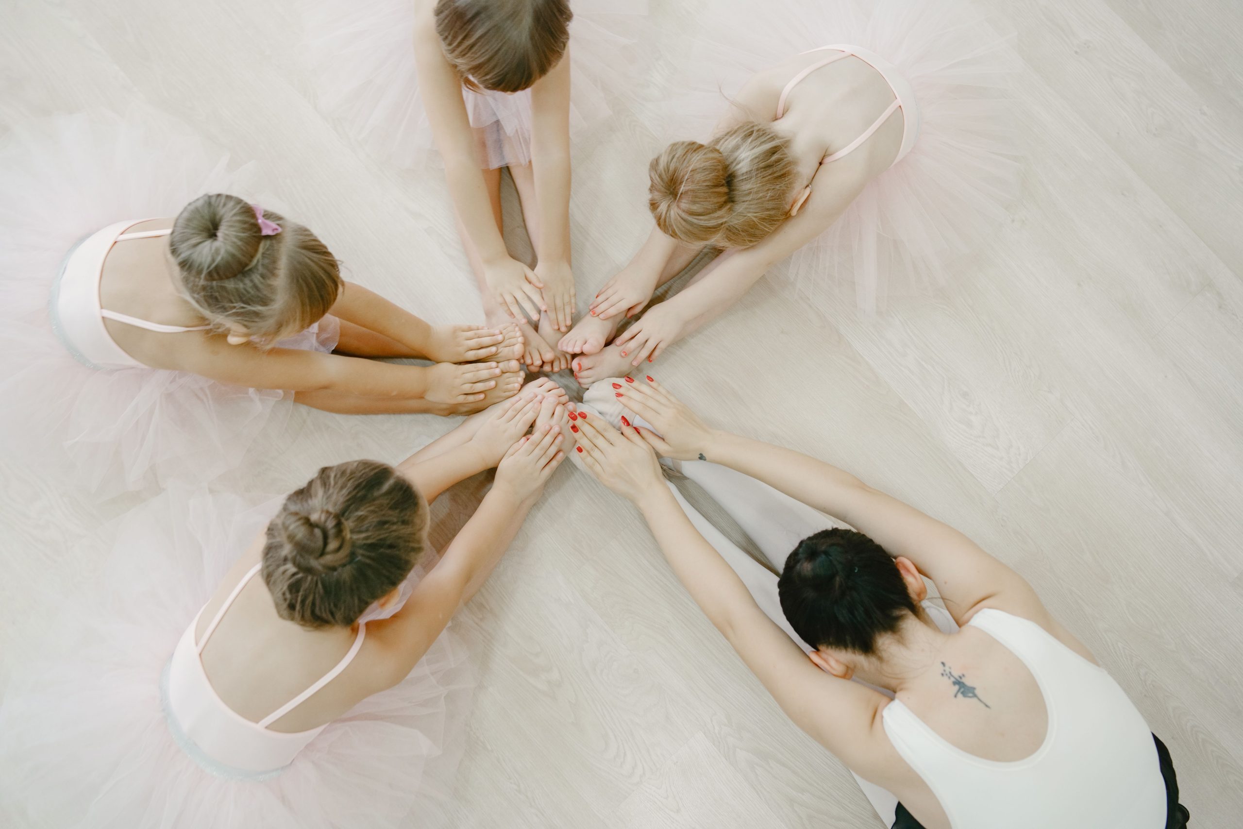 Top view of children in ballet class practicing together on the dance floor.